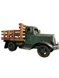 A vintage-style green pickup truck model with a wooden slatted bed, displayed on a yellow shelf in front of a large cardboard box.